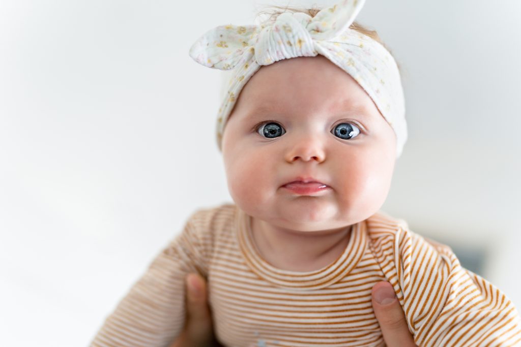 Une adorable petite fille de cinq mois regarde les caméramans.