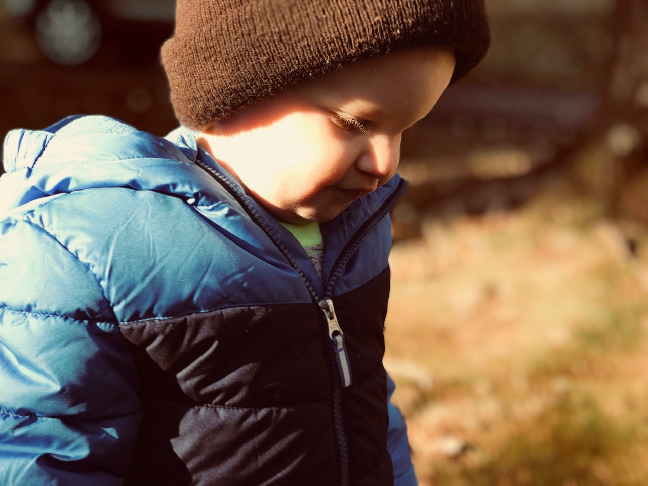 Bébé avec une combinaison d'hiver bleu et un bonnet brun