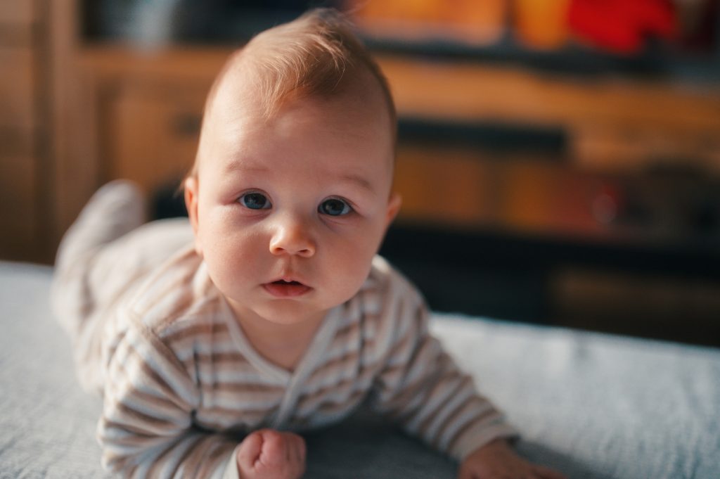 Mignon petit bébé en pyjama se relaxant sur un canapé 