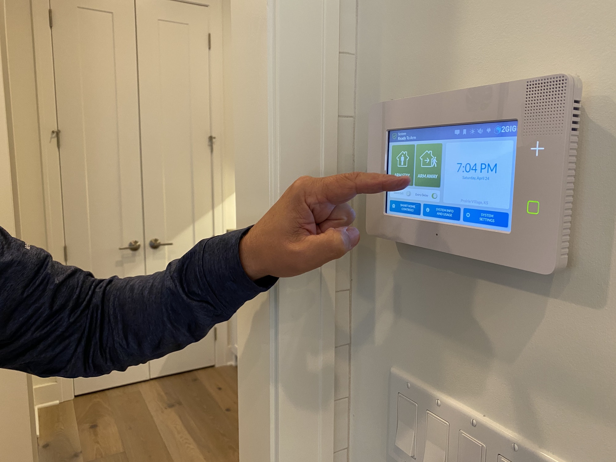 A man sets his alarm on his home security panel at his new house