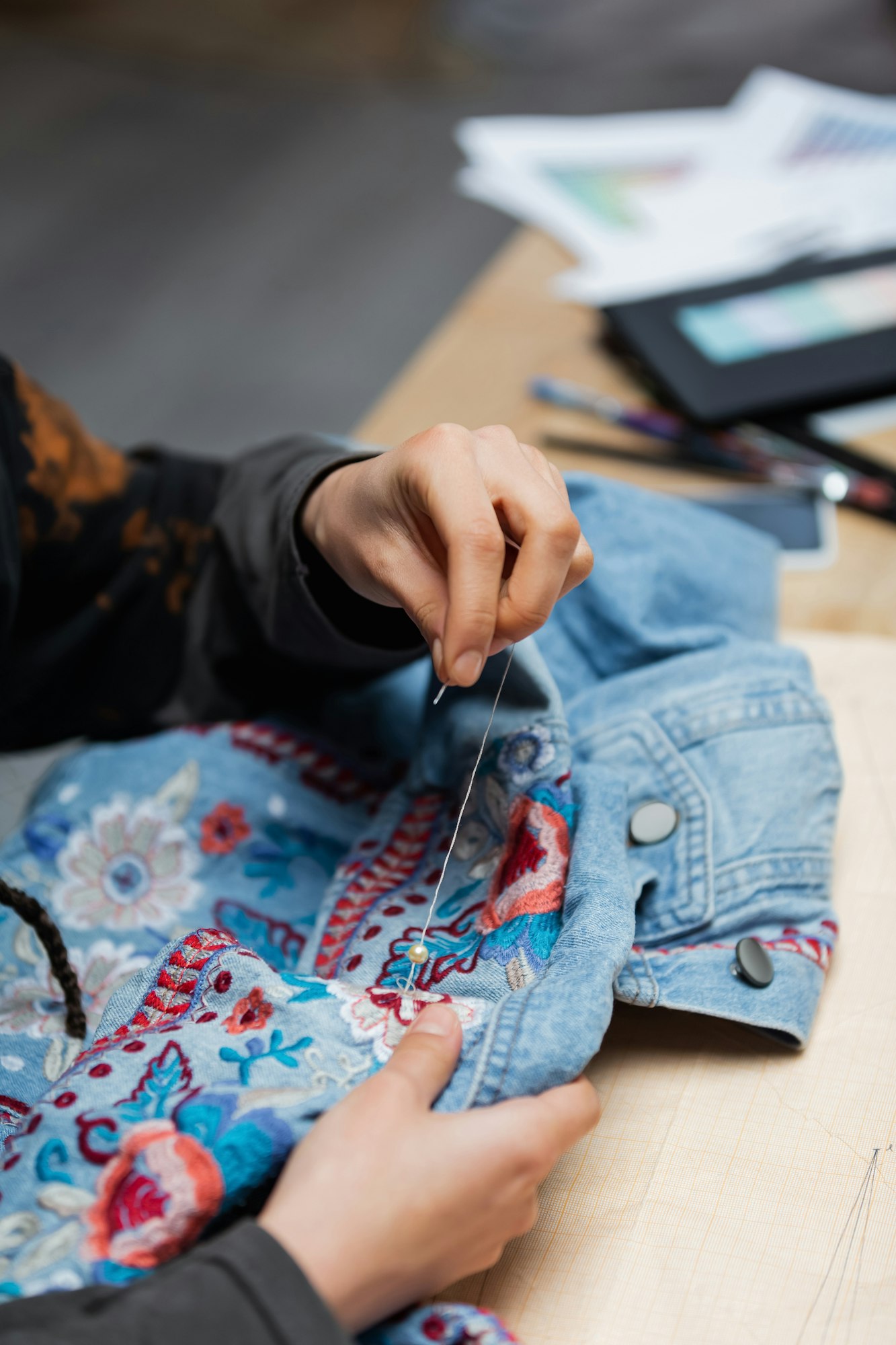 Cropped view of african american craftswoman embroidering denim jacket
