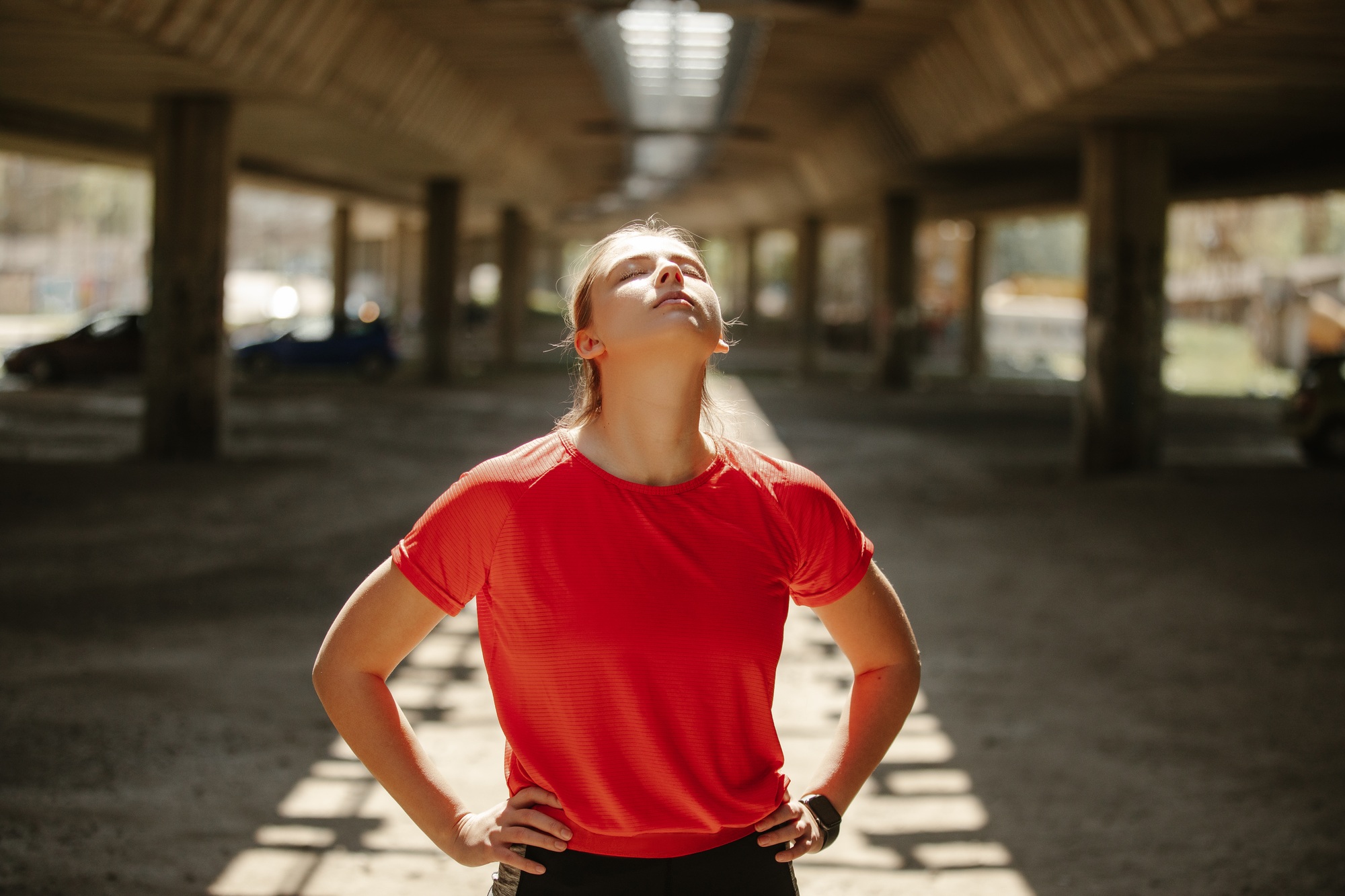 A tired fitness girl takes a breath and enjoys a break before a new series of exercises.